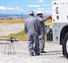 Caliber team members with a wireline truck and wireline logging equipment